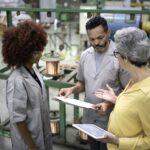gargalos no processo produtivo - funcionários de uma indústria conversando sobre informações da produção