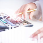 controle de perdas - imagem captando as mãos de uma mulher utilizando calculadora e sobre a imagem gráficos em vetor
