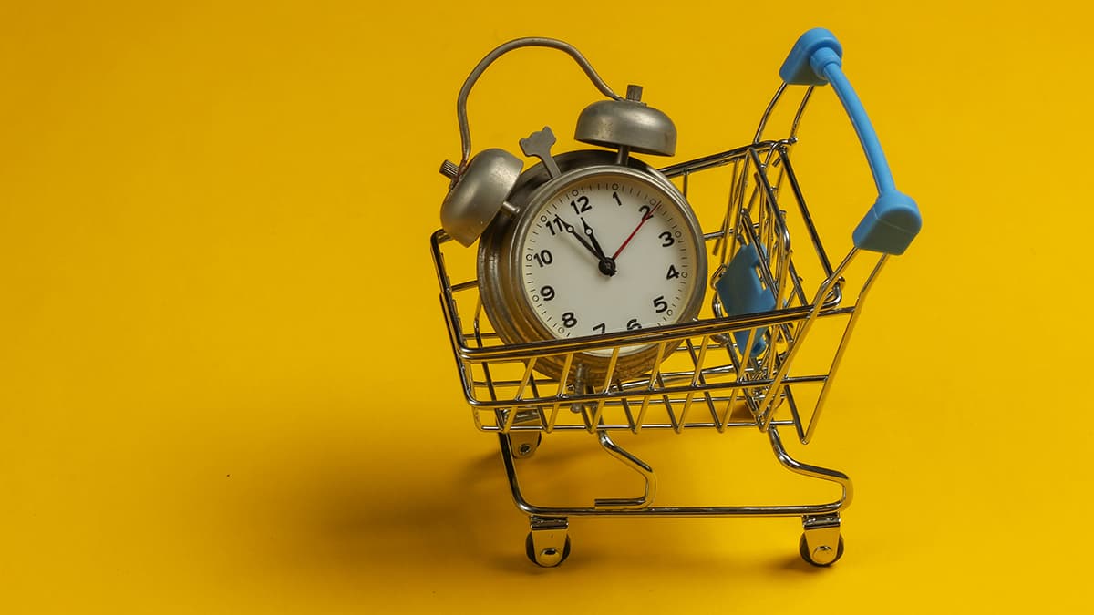 time to market - imagem de um relógio com despertador analógico dentro de um carrinho de compras