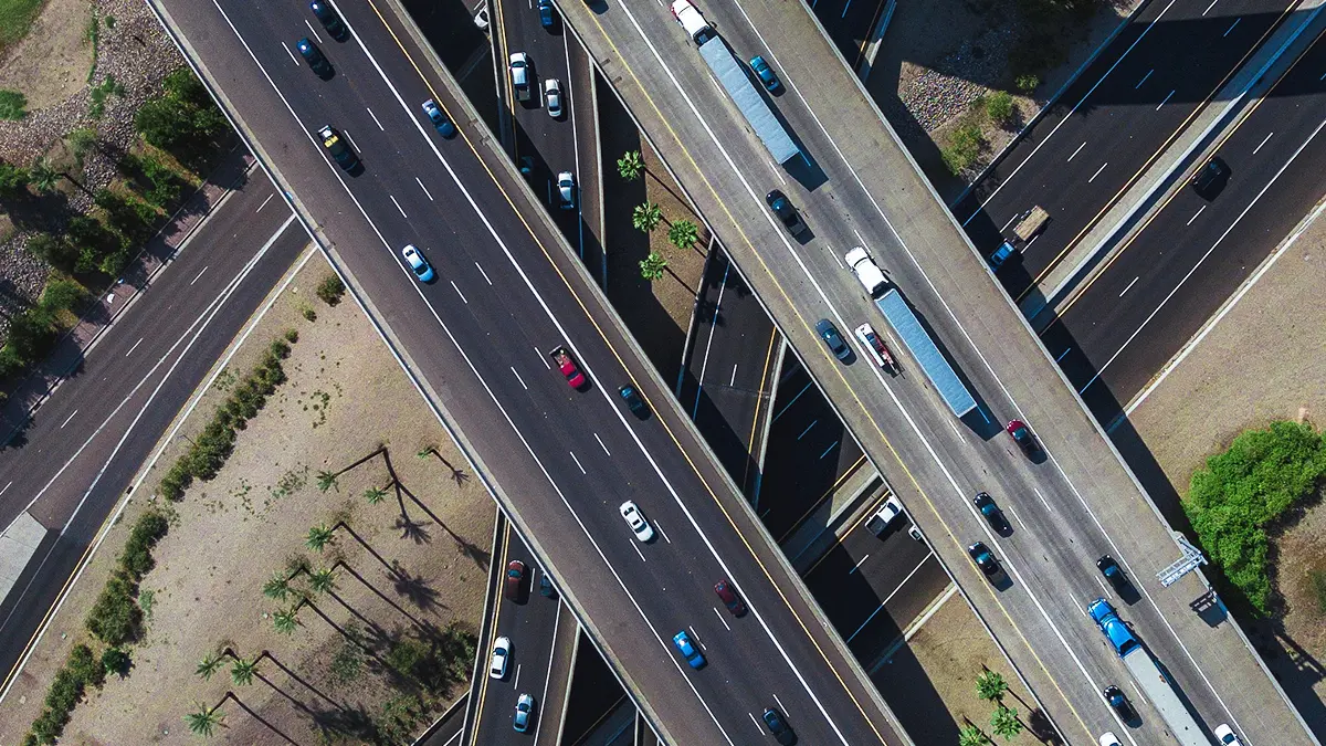 otimização de rotas - imagem vista de cima de rodovias e viadutos onde carros e caminhões passam