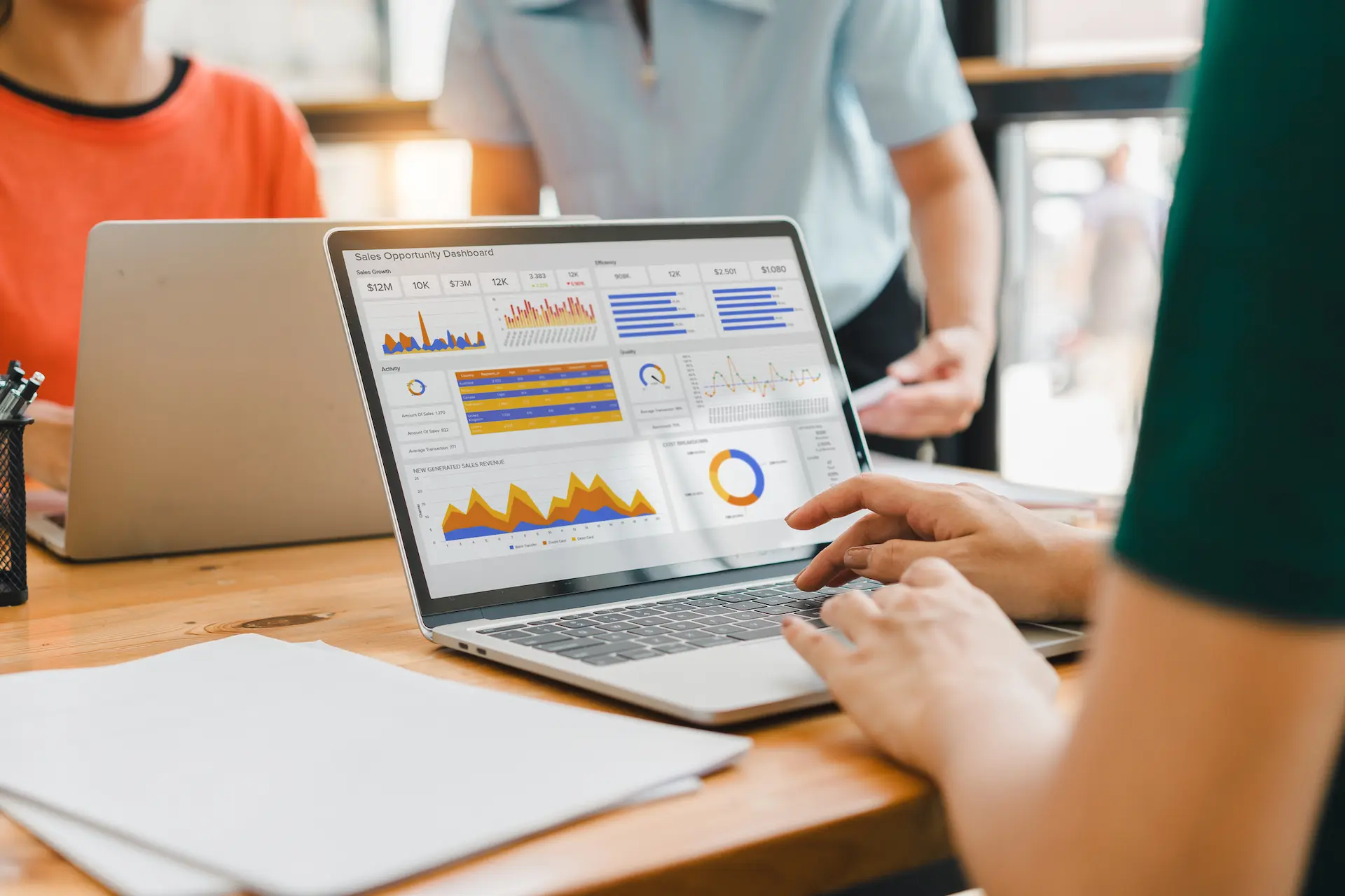 indicadores de desempenho- pessoas analisando KPIs em uma tela de notebook num ambiente de reuniões empresarial
