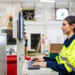 erp para fábrica de móveis - mulher operando software de equipamento em um ambiente fabril moveleiro